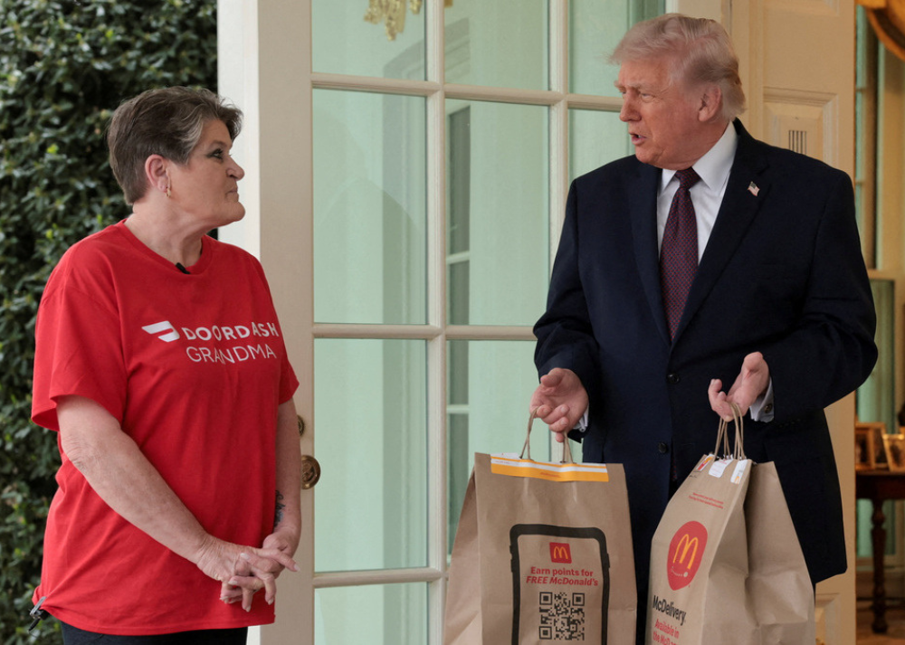 Trump recibe un pedido de McDonald’s en la Casa Blanca junto a una repartidora durante un acto ante los medios.